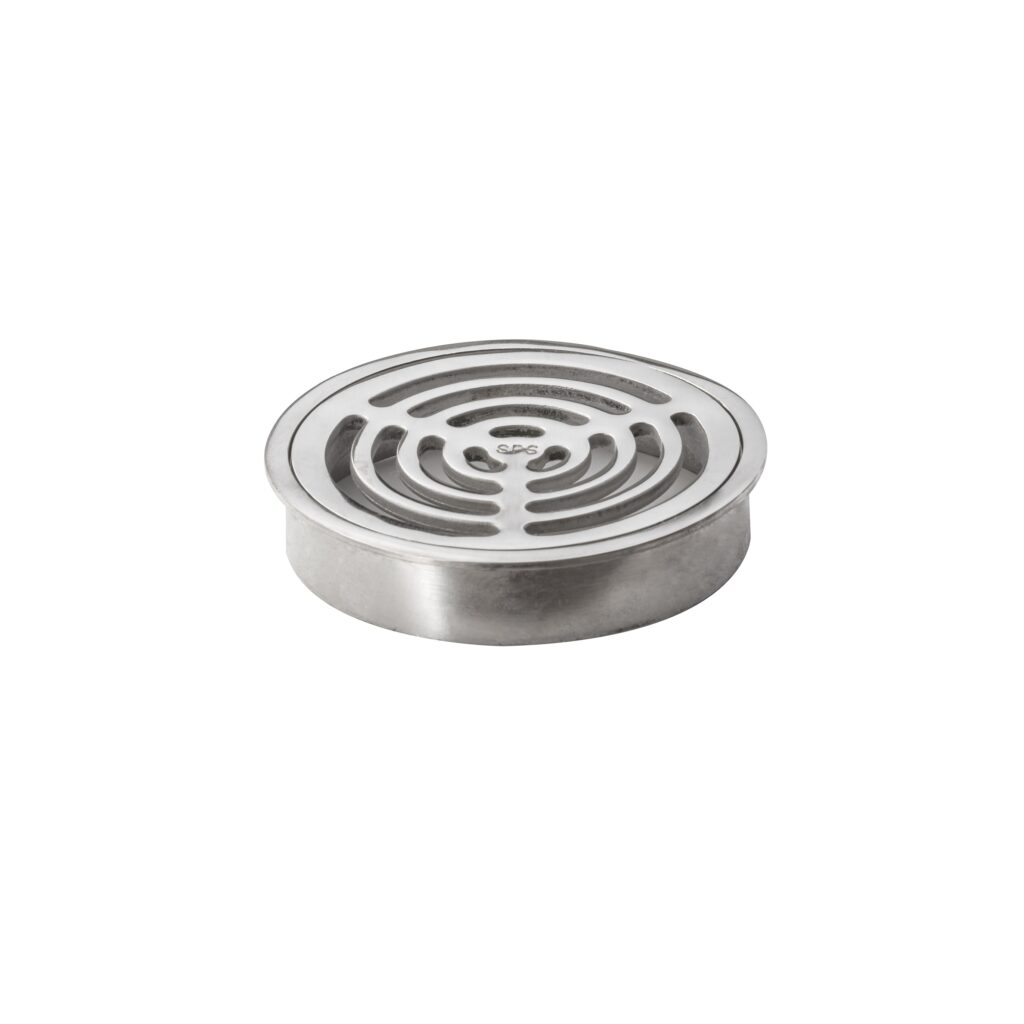 A round, silver metal drain cover with a slotted, circular pattern sits on a white background.