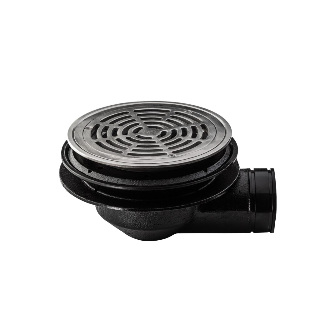 A black floor drain with a round, silver metal grate on top and a side outlet, positioned against a white background.