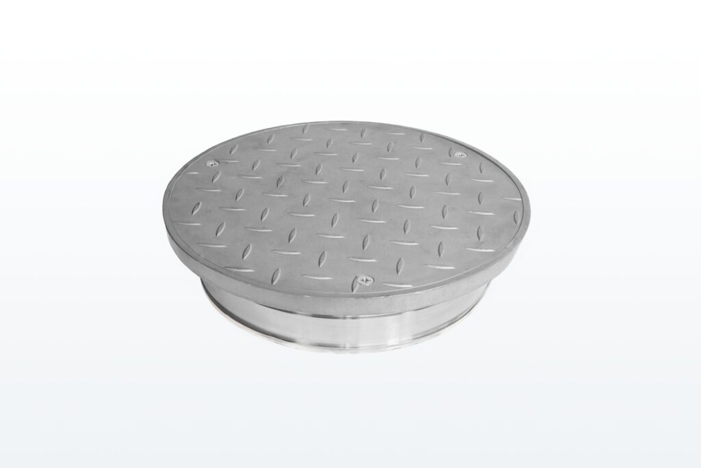 A round metal manhole cover with a textured, diamond plate pattern on its surface, set against a plain white background.